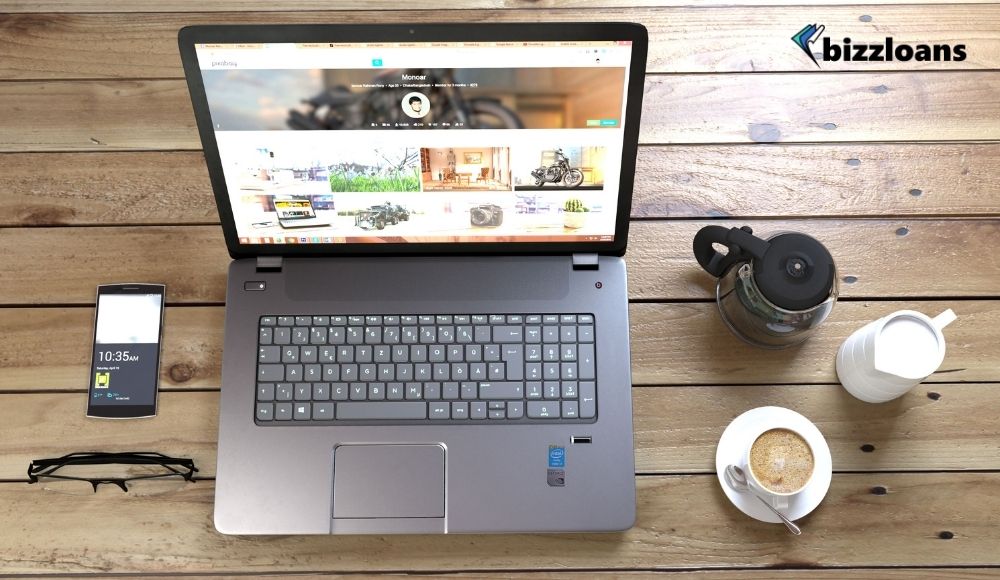 Silver Laptop Next to Coffe CupSmartphone and Glasses