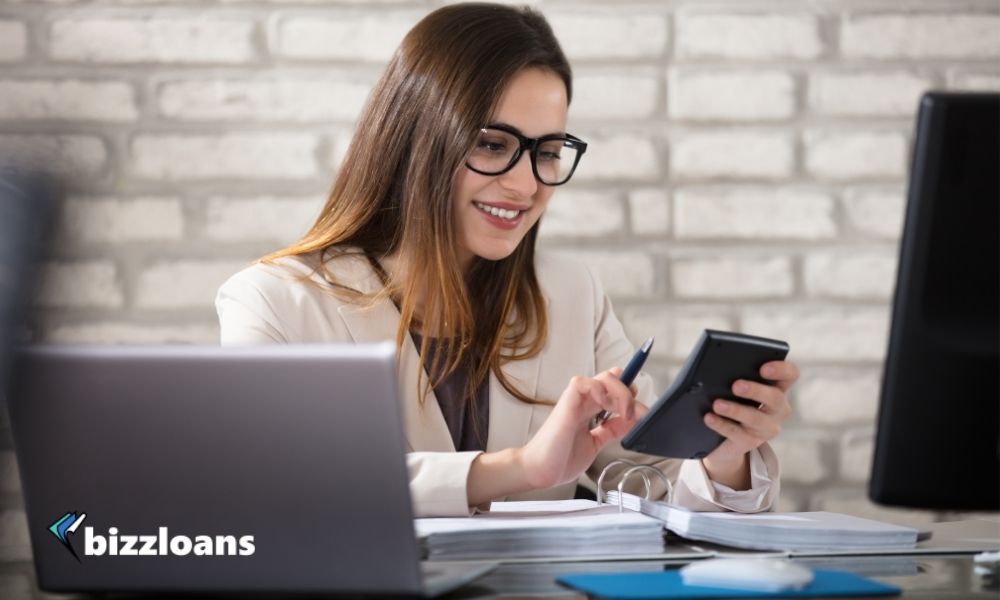 smiling business owner using calculator