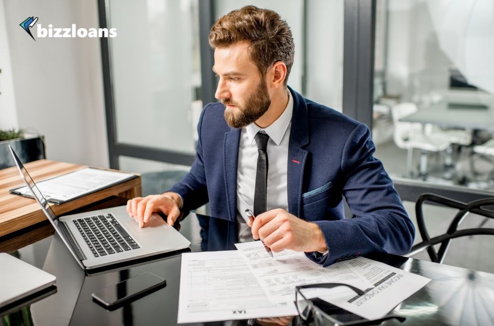 business owner managing his cash flow while looking at his laptop in the office