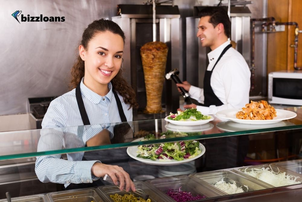 happy staff posing at a kebab counter