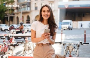 smiling beautiful woman paying with smartphone