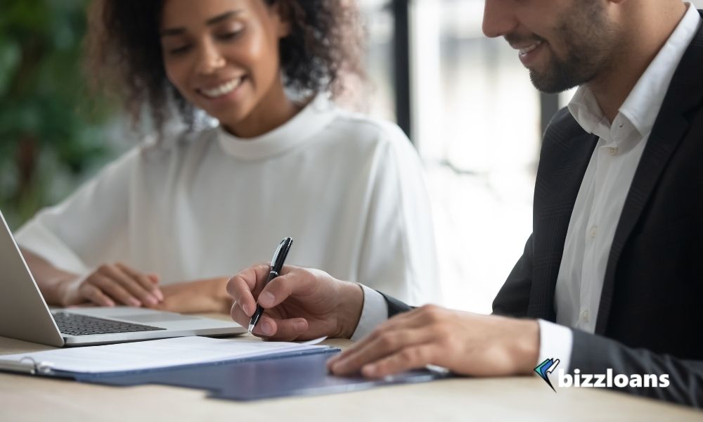 happy business owner signing for a cash flow lending with a female broker