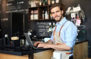 business owner working on laptop in the counter