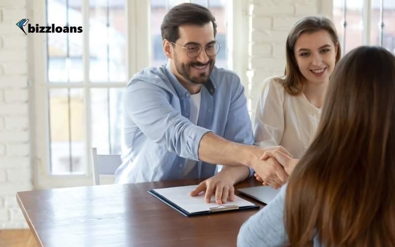 happy business owners shaking hands with a lender