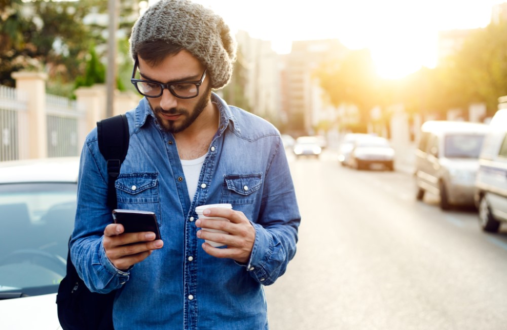 business man comparing business loan on smart phone while walking